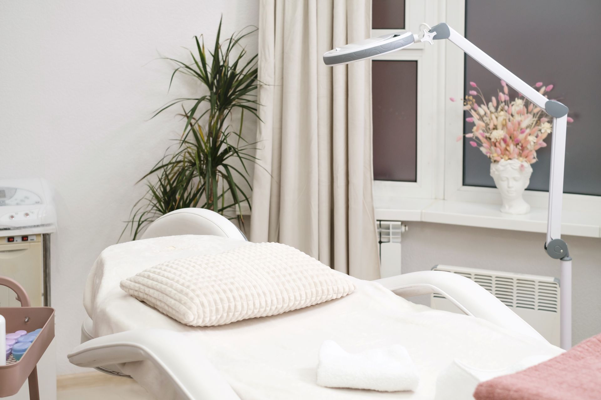 Kosmetischer Behandlungsraum mit Liege und Lupenlampe